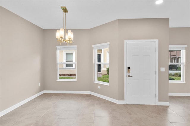 tiled foyer with a chandelier