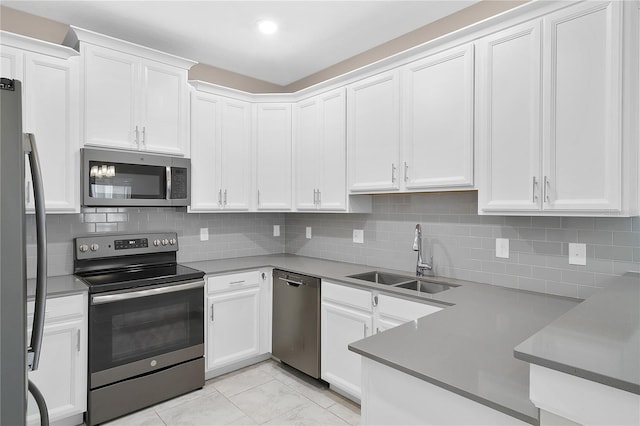 kitchen with white cabinets, appliances with stainless steel finishes, tasteful backsplash, and light tile floors