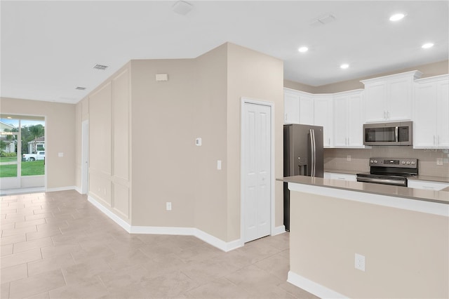 kitchen with stainless steel appliances, white cabinets, tasteful backsplash, and light tile floors