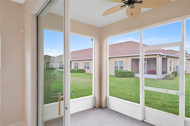 unfurnished sunroom with a healthy amount of sunlight and ceiling fan