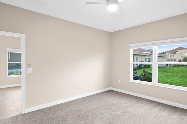 spare room with light tile flooring and ceiling fan