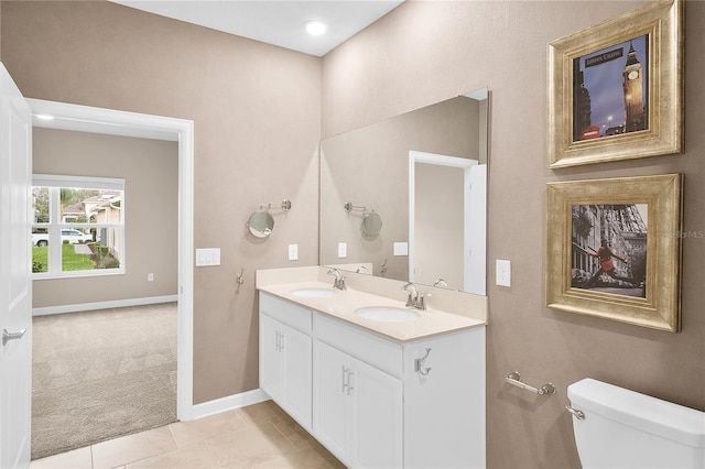 bathroom with double sink, toilet, tile floors, and large vanity