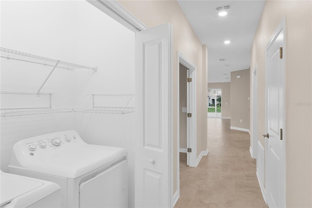 laundry area featuring separate washer and dryer and light tile flooring