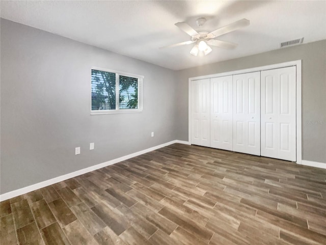 unfurnished bedroom with hardwood / wood-style floors, a closet, and ceiling fan