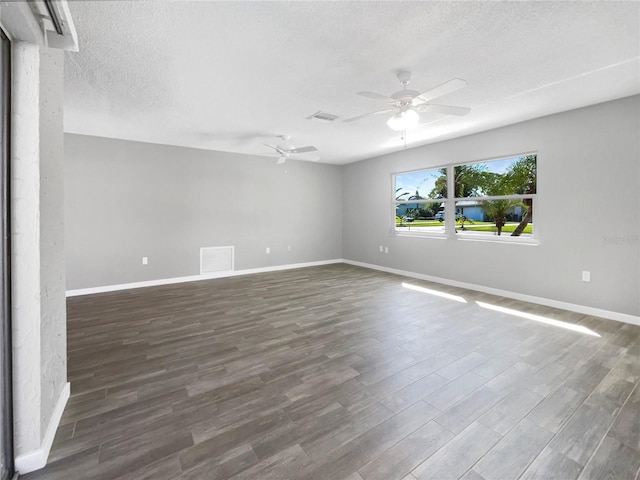 empty room with a textured ceiling, dark hardwood / wood-style flooring, and ceiling fan