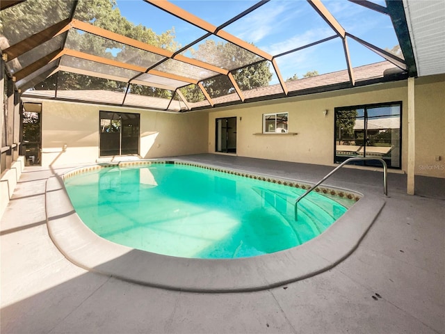 view of pool featuring glass enclosure and a patio area