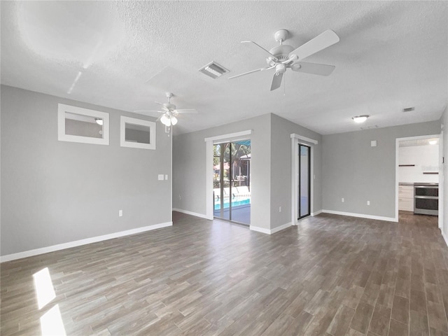 unfurnished living room with wood-type flooring, a textured ceiling, and ceiling fan