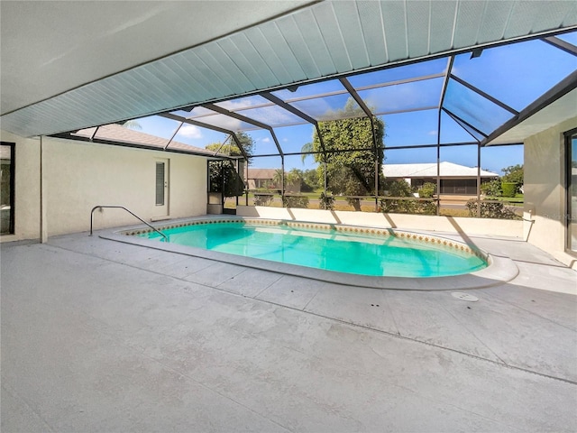 view of swimming pool featuring glass enclosure and a patio