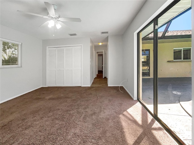 unfurnished bedroom with access to outside, ceiling fan, a closet, and dark carpet