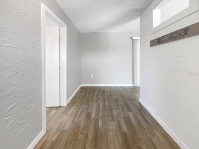 hall with dark hardwood / wood-style flooring and a textured ceiling