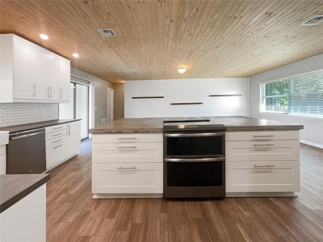 kitchen featuring dark wood-type flooring, tasteful backsplash, white cabinets, wood ceiling, and appliances with stainless steel finishes