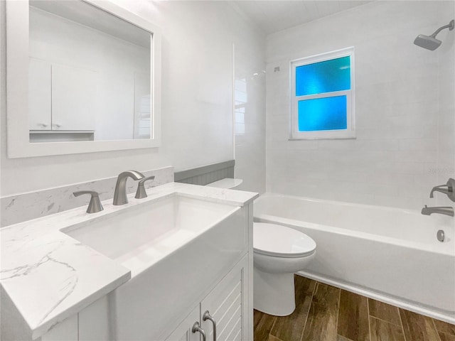 full bathroom with hardwood / wood-style floors, vanity, toilet, and tiled shower / bath combo