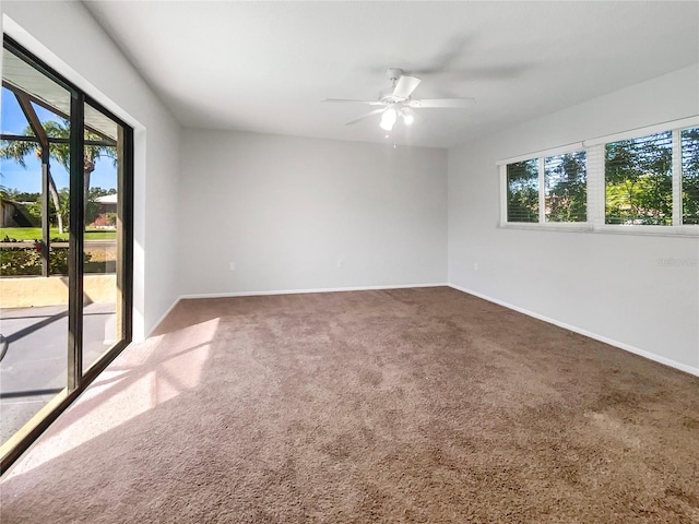 carpeted spare room featuring ceiling fan