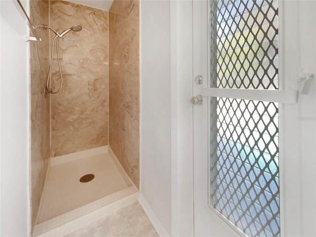 bathroom featuring tile patterned flooring and a tile shower