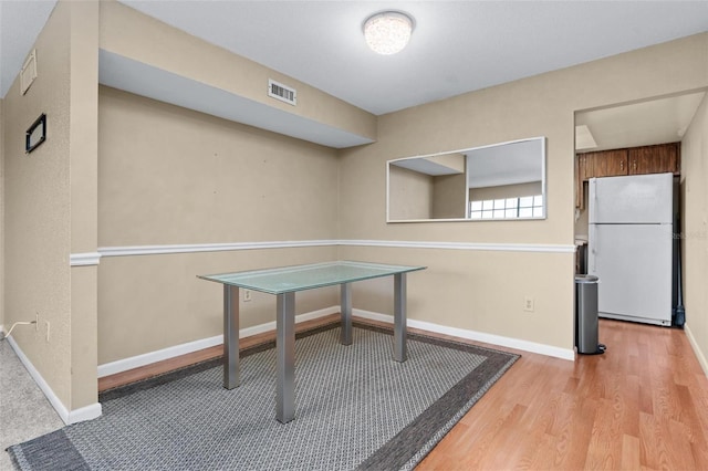 home office with light hardwood / wood-style flooring