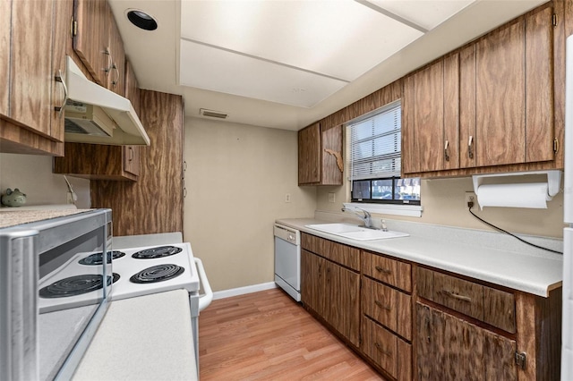 kitchen with white appliances, sink, and light hardwood / wood-style flooring