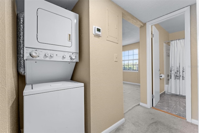 laundry room featuring stacked washer / drying machine and light carpet