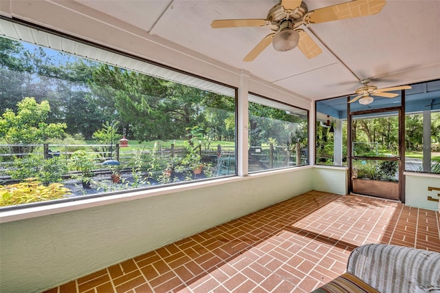 unfurnished sunroom featuring ceiling fan