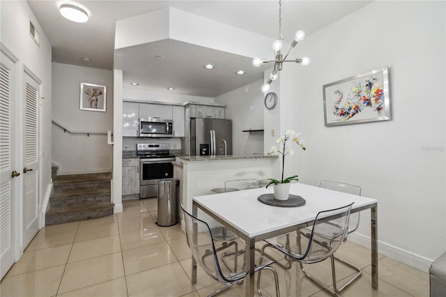 tiled dining area featuring an inviting chandelier