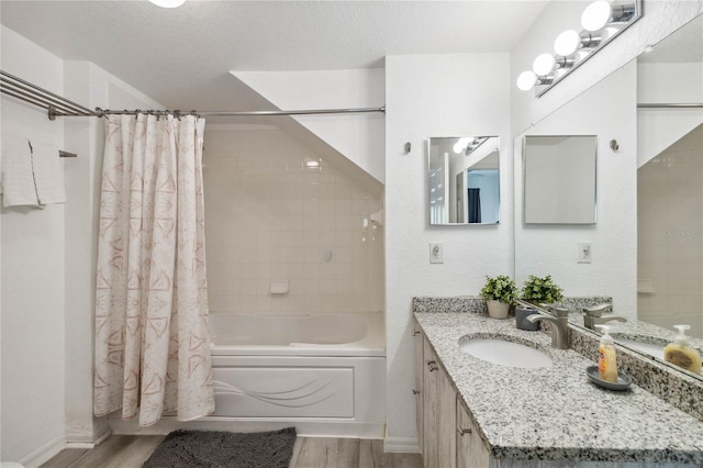 bathroom featuring shower / bath combo with shower curtain, hardwood / wood-style floors, vanity, and a textured ceiling