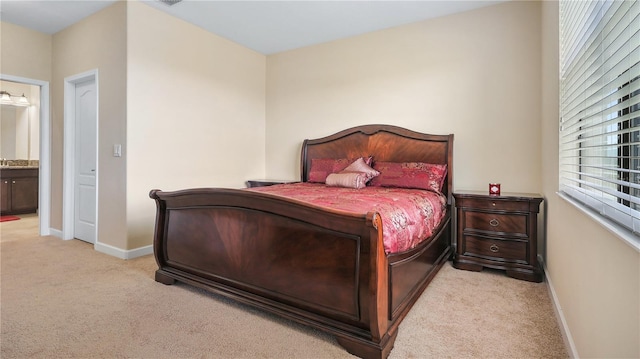 bedroom with ensuite bath and light colored carpet