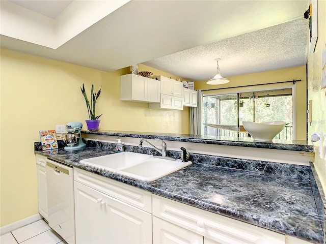 kitchen featuring dishwasher, sink, a textured ceiling, light tile patterned flooring, and white cabinetry