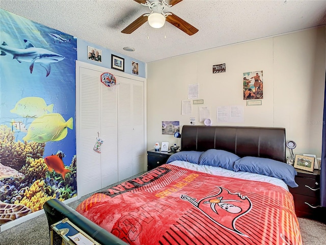 carpeted bedroom featuring ceiling fan, a closet, and a textured ceiling