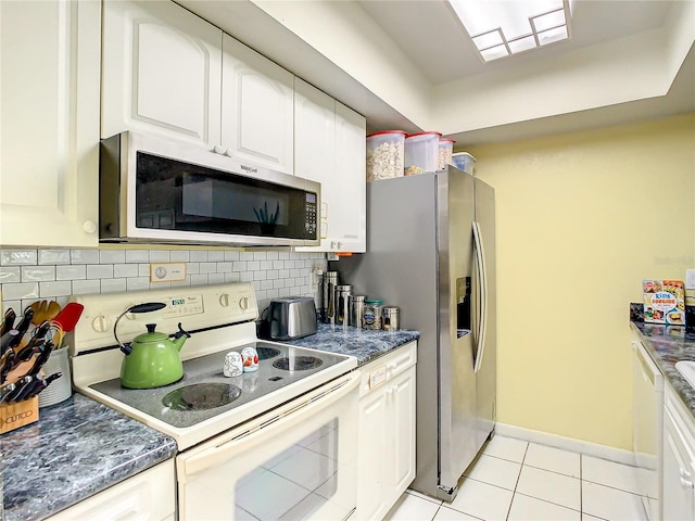 kitchen featuring white cabinets, decorative backsplash, light tile patterned floors, and stainless steel appliances