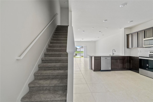 staircase featuring tile patterned flooring, a textured ceiling, and sink