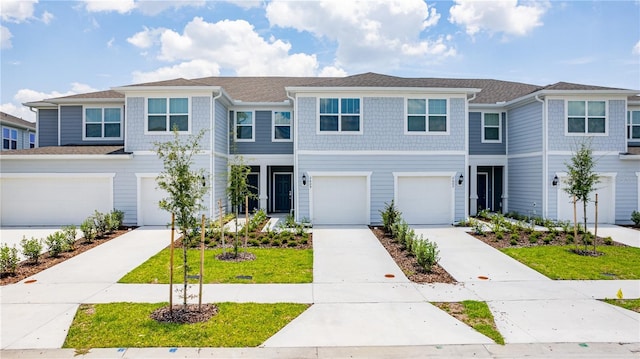 multi unit property featuring a garage and a front lawn