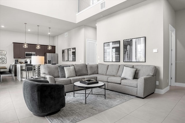 living room featuring a towering ceiling and light tile patterned floors