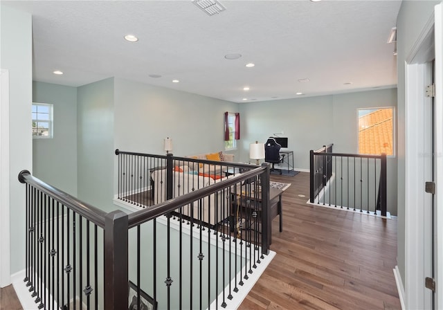 corridor featuring a textured ceiling and dark hardwood / wood-style flooring