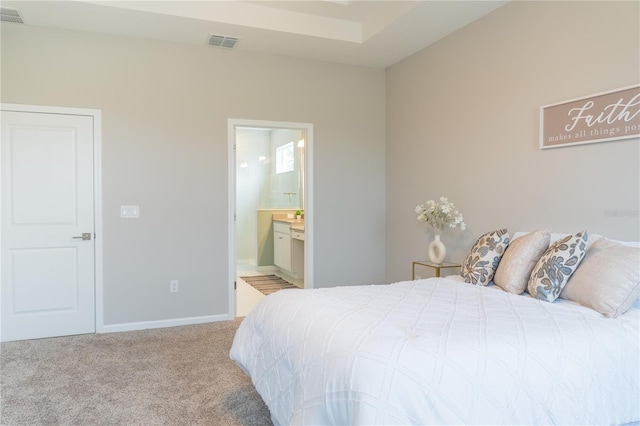 bedroom featuring connected bathroom and carpet flooring