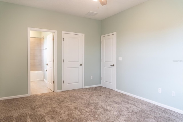 unfurnished bedroom featuring light carpet, ceiling fan, and ensuite bathroom