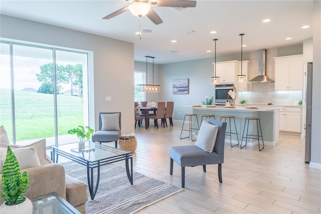 living room with light hardwood / wood-style flooring and ceiling fan