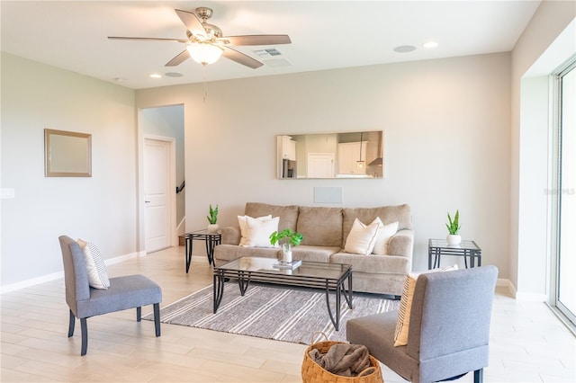 living room with ceiling fan, light wood-type flooring, and a healthy amount of sunlight