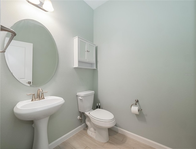 bathroom featuring hardwood / wood-style flooring and toilet