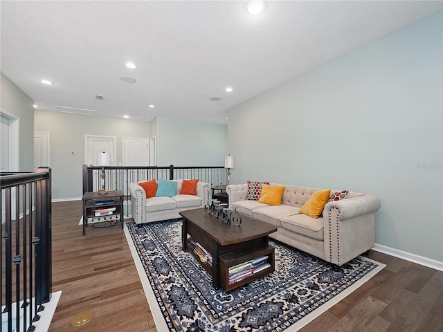 living room with a textured ceiling and dark hardwood / wood-style floors