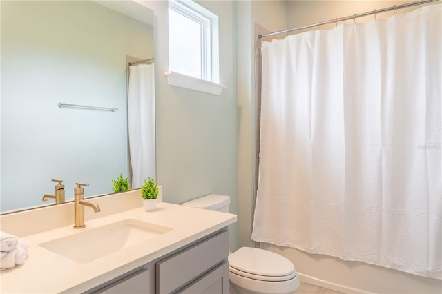 full bathroom featuring shower / bath combo, vanity, and toilet