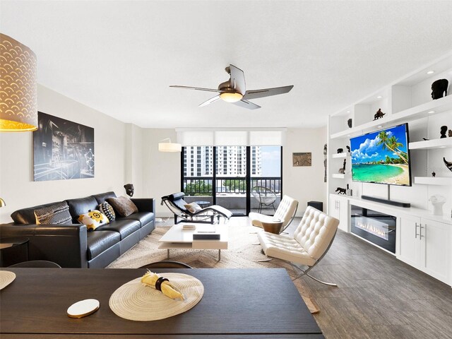 living room featuring hardwood / wood-style flooring, a wall of windows, and ceiling fan