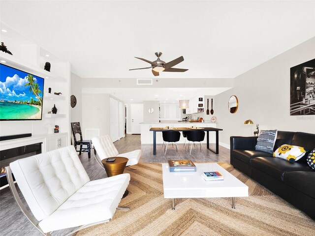 living room featuring light hardwood / wood-style flooring and ceiling fan