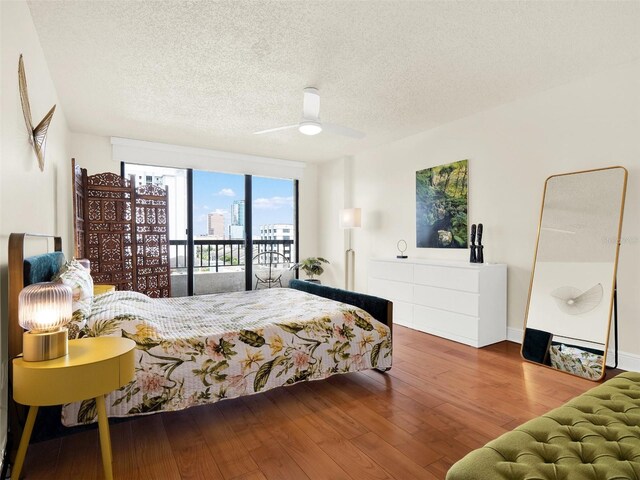 bedroom featuring hardwood / wood-style floors, a textured ceiling, ceiling fan, and access to outside