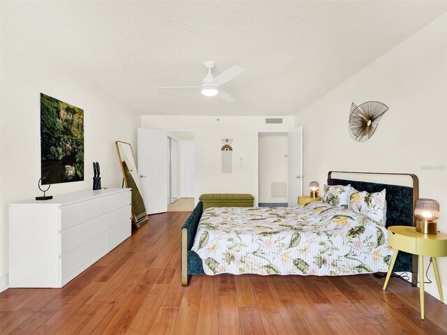 bedroom with wood-type flooring, a textured ceiling, and ceiling fan