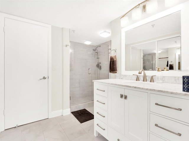 bathroom featuring a shower with shower door and vanity