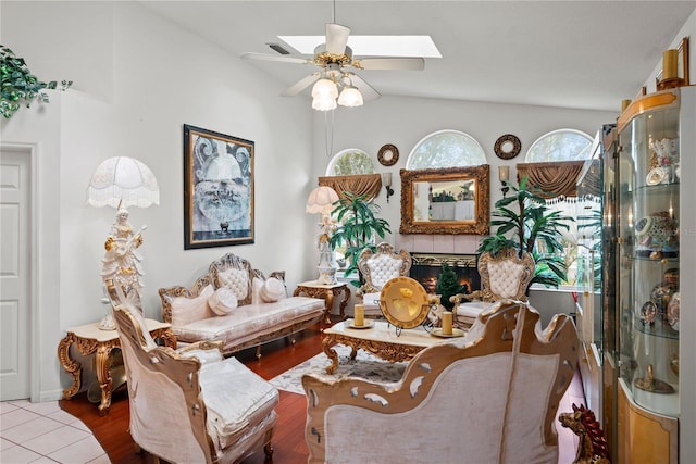 living room with lofted ceiling, light tile patterned floors, a fireplace, and ceiling fan