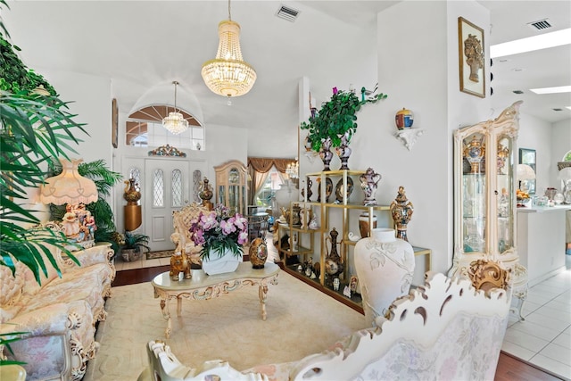 living room with lofted ceiling, hardwood / wood-style floors, and a notable chandelier