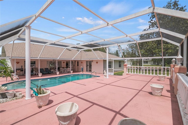 view of pool with a patio area and glass enclosure