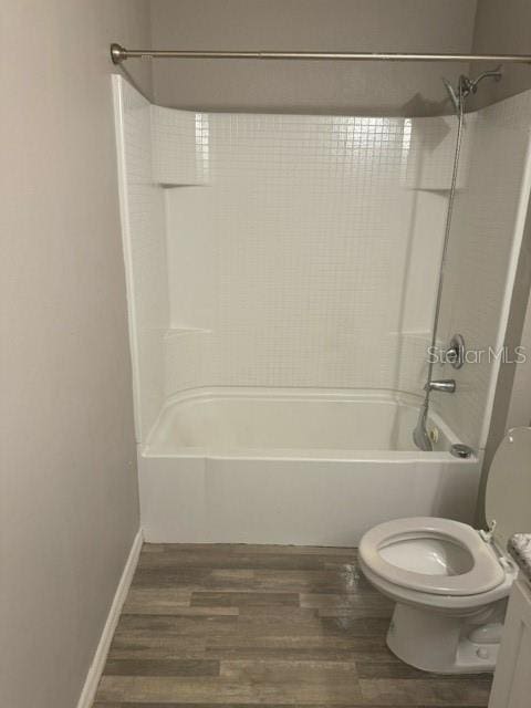 full bathroom featuring hardwood / wood-style floors, vanity,  shower combination, and toilet