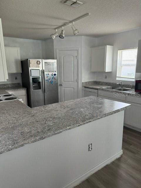 kitchen with rail lighting, sink, stainless steel fridge with ice dispenser, a textured ceiling, and white cabinetry