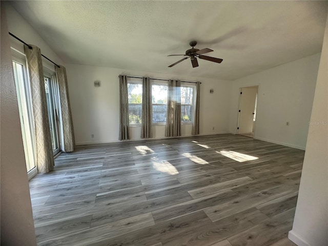 spare room with ceiling fan, hardwood / wood-style floors, and a textured ceiling